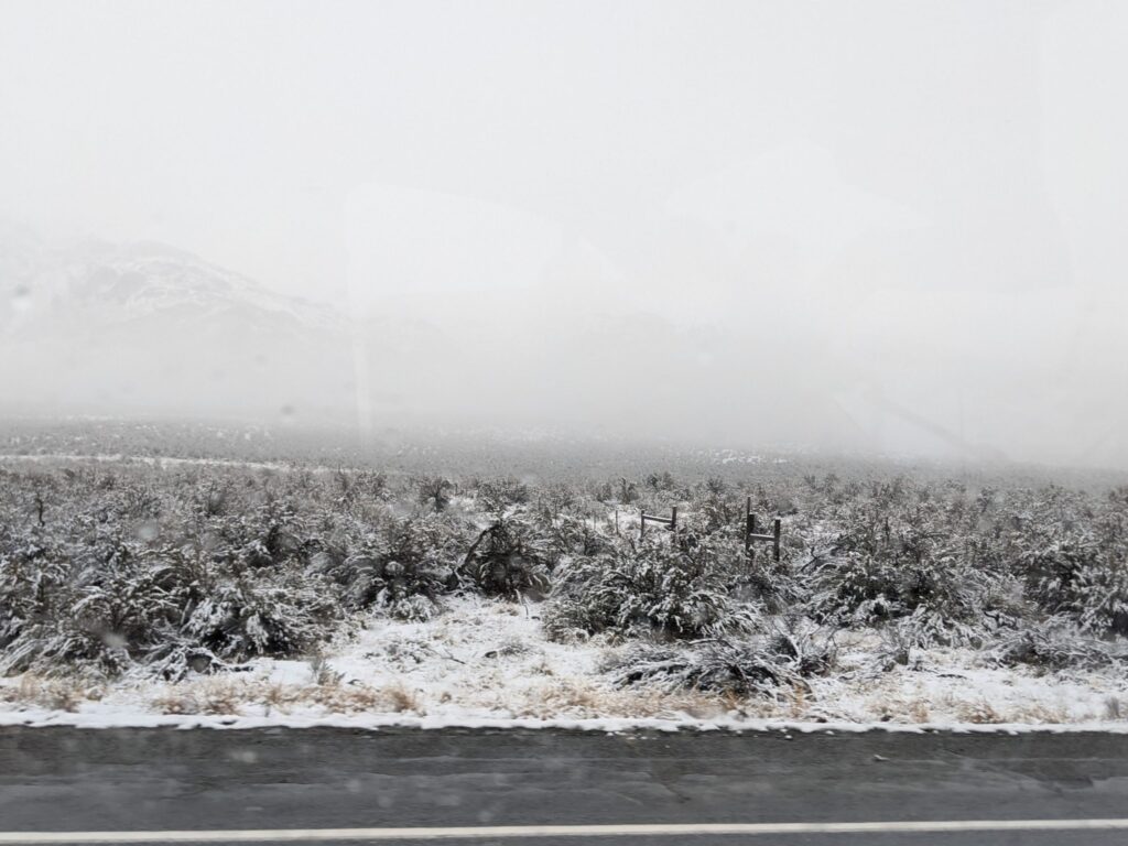 Snow covered valleys and mountains covered in fog.
