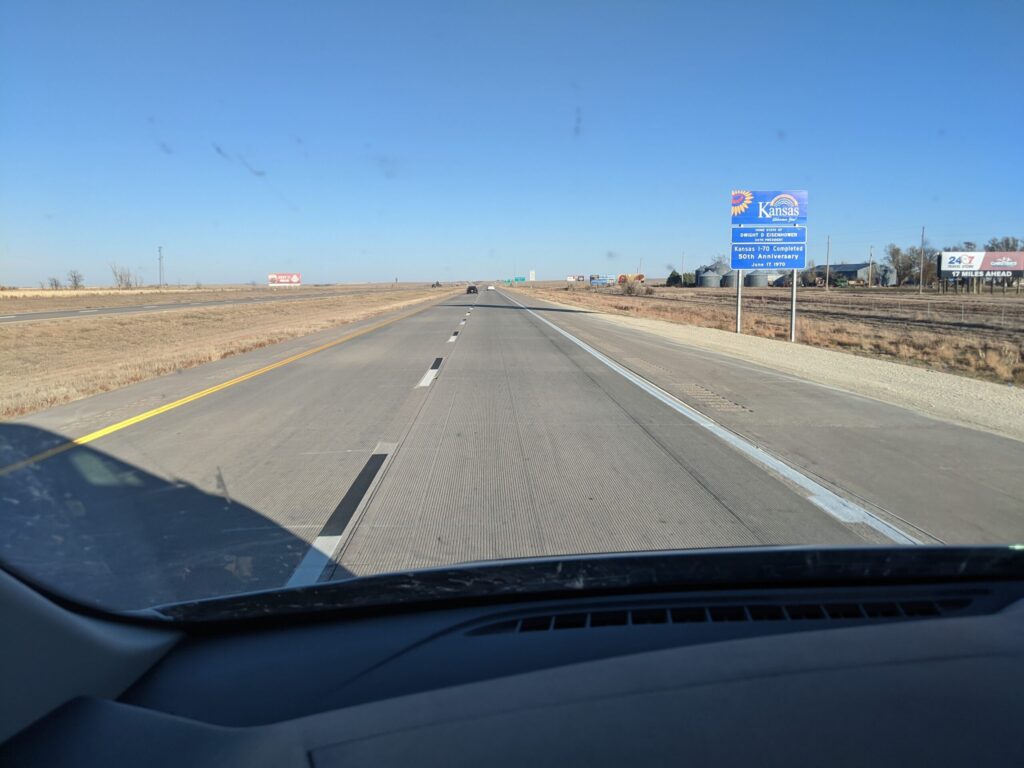 Driving down the freeway with the Kansas state welcome sign in view