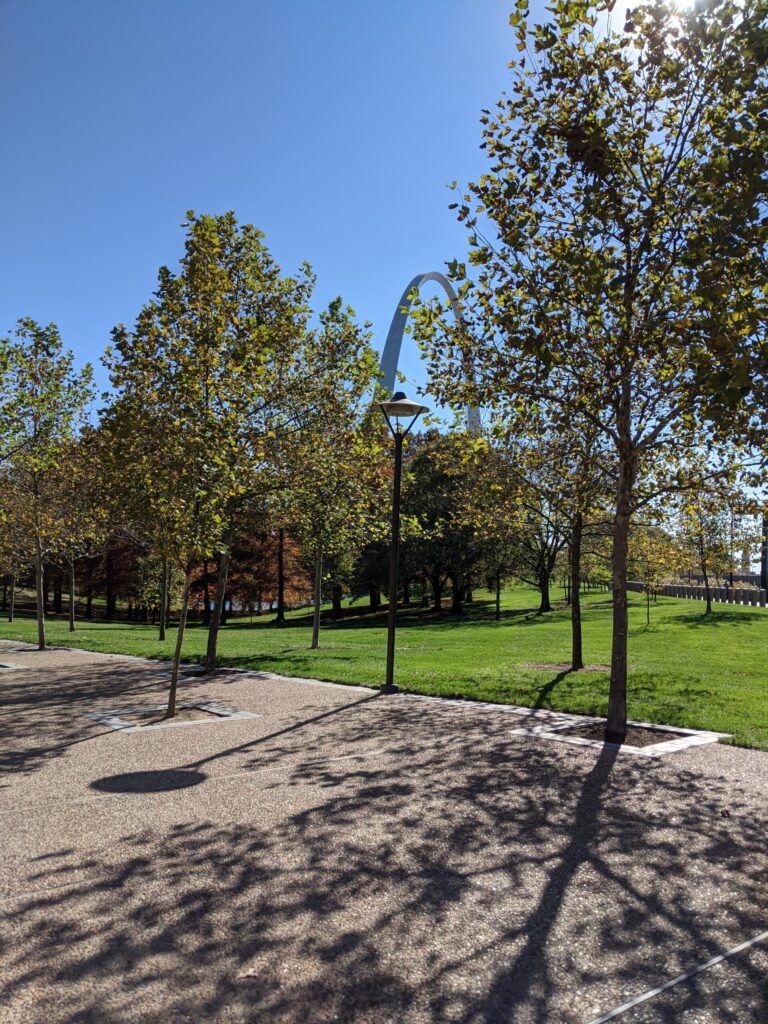 grass, trees, and arch in the background