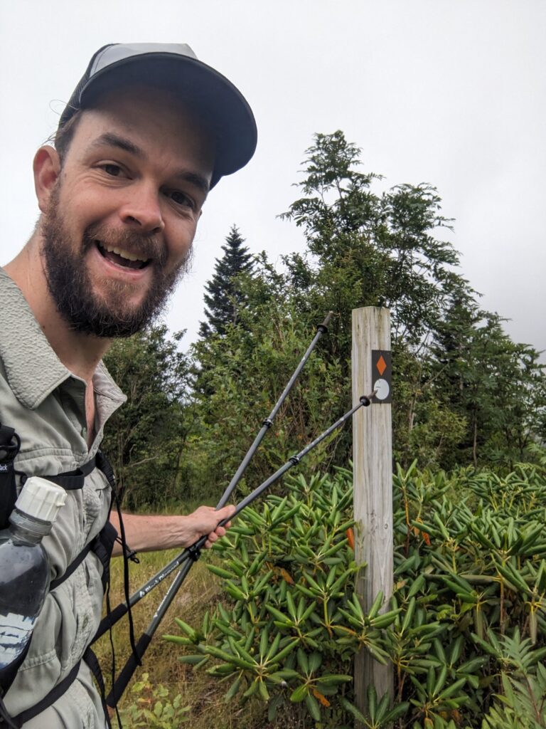 Me pointing to the MST blaze with my hiking pole